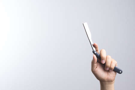 Hand holding razor use in barber on white backgroundの写真素材