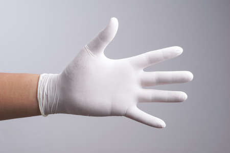 Hand wearing latex glove on white backgroundの写真素材
