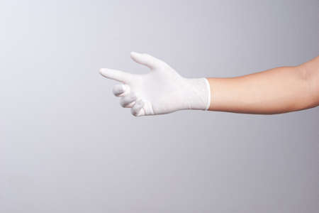 Hand wearing latex glove on white backgroundの写真素材