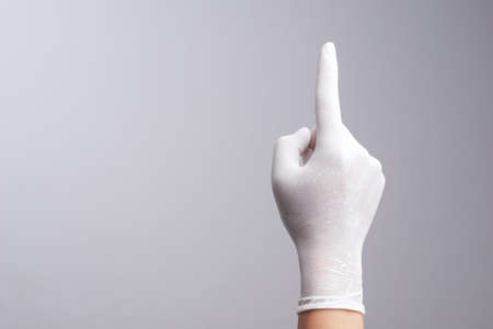 Hand wearing latex glove with number one index finger on white backgroundの写真素材