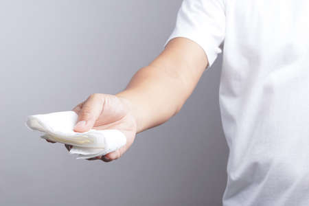 Hand giving tissue paper on white backgroundの写真素材