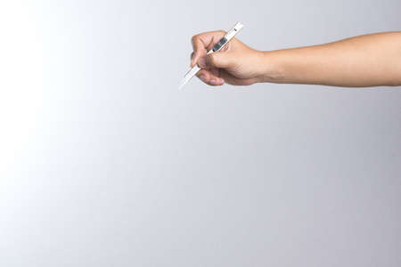 Hand holding paper cutter on white backgroundの写真素材
