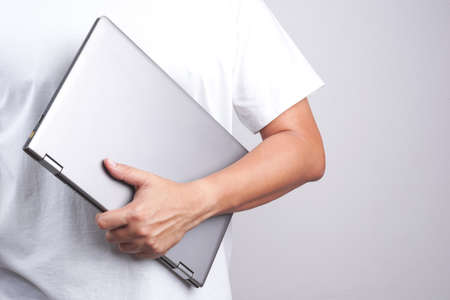 Hand holding laptop on white backgroundの写真素材