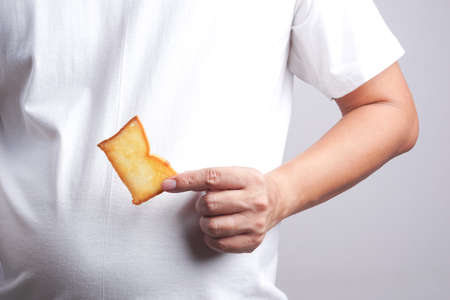 Hand holding butter rusk bread loaf on white background