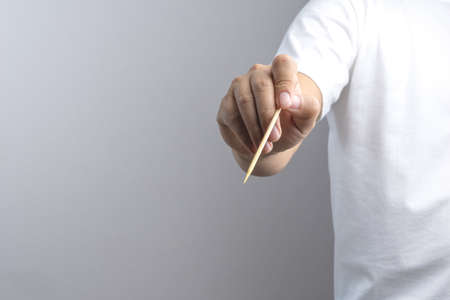 Hand holding empty wooden stick on white backgroundの写真素材