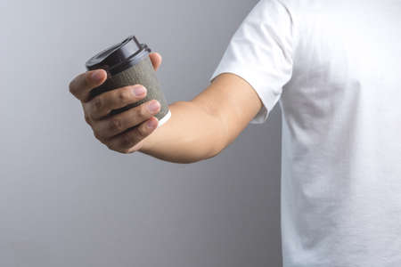 Hand holding hot coffee cup on white backgroundの写真素材