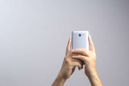 Hand taking a photo or video by mobile phone on white background