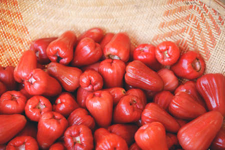 Fresh red rose apples in straw basket