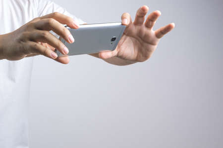 Hand taking a photo or video by mobile phone on white backgroundの写真素材
