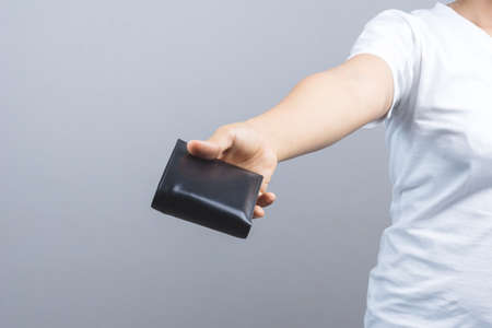 Woman hand holding man wallet on grey background