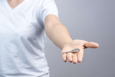 Woman hand giving key on grey background