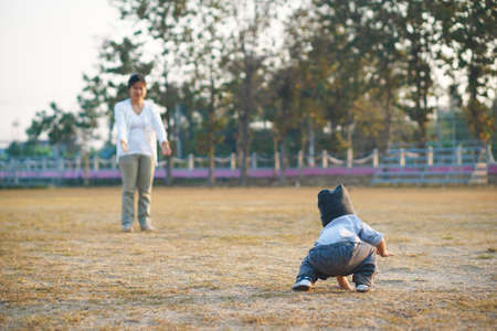 Asian mother teach her 1 year and a month son to walk, life concept