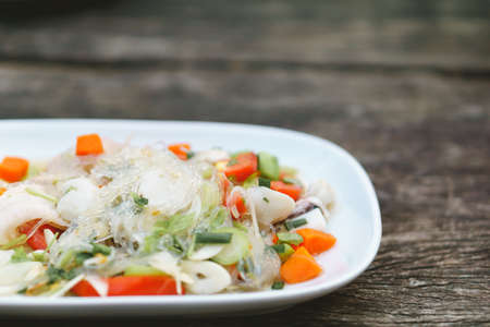 Spicy Thai seafood salad on wooden backgroundの写真素材