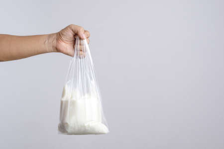 Hand holding homemade yogurt on white backgroundの写真素材