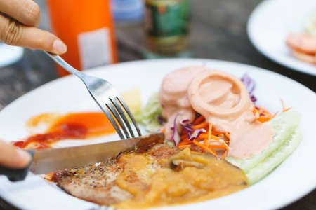 Thin and small steak with salad for diet person on wooden backgroundの写真素材