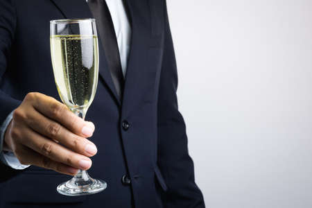 Business man hand holding glass of champagne for celebration on white background