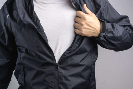 Man wearing black anti static or wet weather jacket or rain coat on white backgroundの写真素材