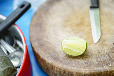 Lime with a knife on old wooden cutting boardの写真素材