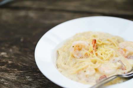 Prawn spaghetti carbonara on wooden backgroundの写真素材