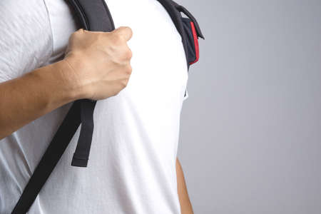 Hand holding bag backpack bag strap on white backgroundの写真素材