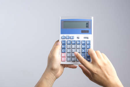 Hand holding calculator on white backgroundの写真素材