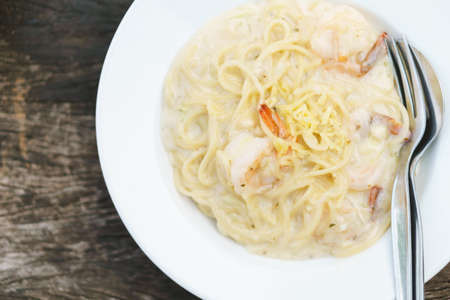 Prawn spaghetti carbonara on wooden backgroundの写真素材