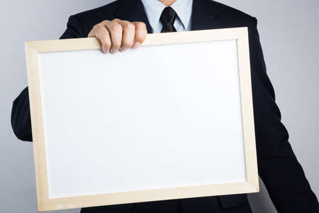 Business man hand holding blank wooden frame on white backgroundの写真素材