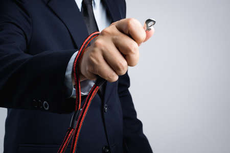 Business man hand holding animal collar strap on white backgroundの写真素材