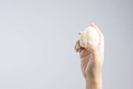 Hands holding cooked sticky rice as the original way to eat Thai food on white backgroundの写真素材