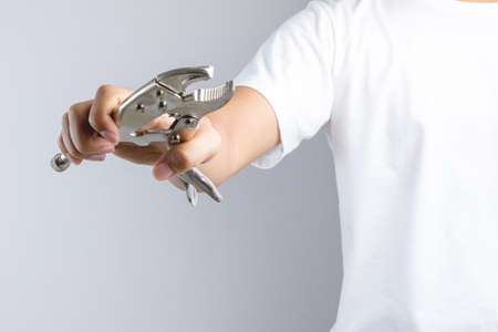 Hand holding locking pliers or mole grips on white backgroundの写真素材