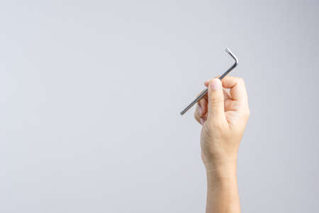 Hand holding Allen wrench on white backgroundの写真素材