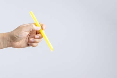 Hand holding a big or extra large drinking straw on white backgroundの写真素材