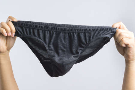 Hand holding man underwear or underpants for men on white backgroundの写真素材