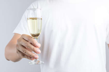 Hand holding glass of champagne with pest or insect on white backgroundの写真素材