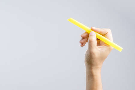 Hand holding a big or extra large drinking straw on white backgroundの写真素材