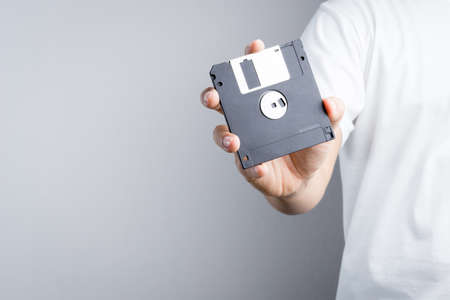 Hand holding floppy disk on white backgroundの写真素材