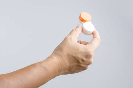 Hand holding contact lens case on white backgroundの写真素材