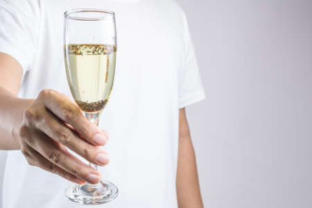 Hand holding glass of champagne with pest or insect on white backgroundの写真素材