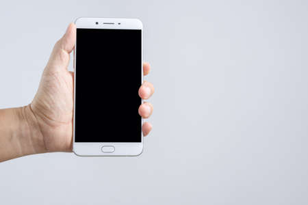 Hand holding new 6 inch smart phone with blank screen on white backgroundのeditorial素材