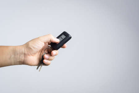 Hand holding and press car remote control on white background