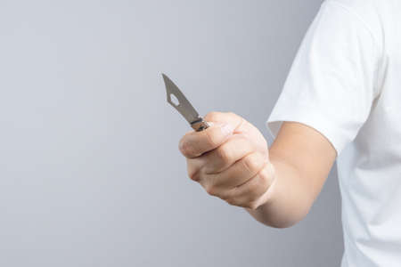 Hand holding sharp pocket fold metal knife on white backgroundのeditorial素材