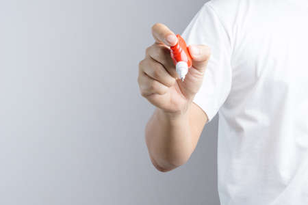 Hand holding correction pen or liquid paper for correct hand writing mistakes on white backgroundのeditorial素材