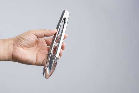 Hand holding silver serving kitchen tongs for picking food on white backgroundのeditorial素材