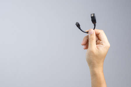 Hand holding adapter USB to micro USB cable connector on white backgroundのeditorial素材