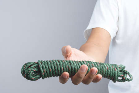 Hand holding green parachute cord of nylon rope on white backgroundのeditorial素材