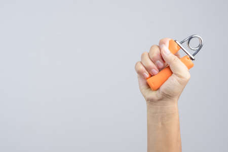 Hand exercising strength using hand gripper on white backgroundのeditorial素材
