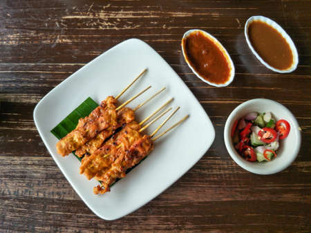 Thai food, grilled pork Satay with peanut sauce and pickles from cucumber slices and onions in vinegarの写真素材