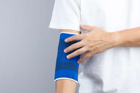 Arm with elastic elbow support and hurt gesture on white backgroundのeditorial素材