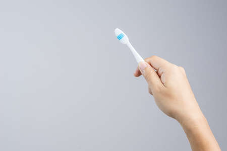 Hand holding clean and new toothbrush on white backgroundのeditorial素材