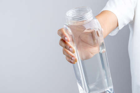 Hand holding full 1.4 lites water bottle on white backgroundのeditorial素材